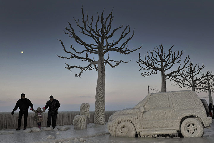 Europe weather: People walk along an icy promenade at Lake Geneva