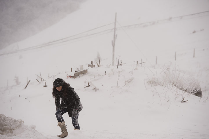 Europe weather: A woman tries to walks in the snow on the way to Ibaneta, Spain