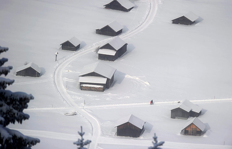 Europe weather: People walk over a snow covered fields in Garmisch-Partenkirchen, Germany,