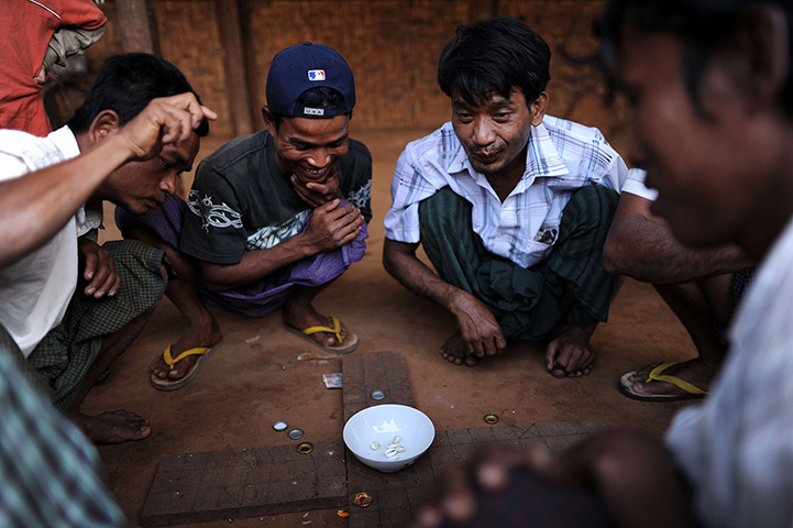 24 hours: Mandalay, Burma: Men play a game with shells at a market