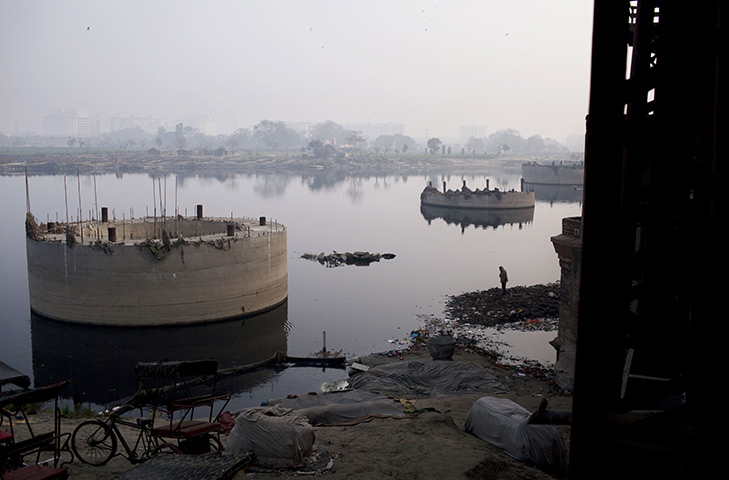 24 hours: New Delhi, India: A man searches for items to salvage in the River Yamuna