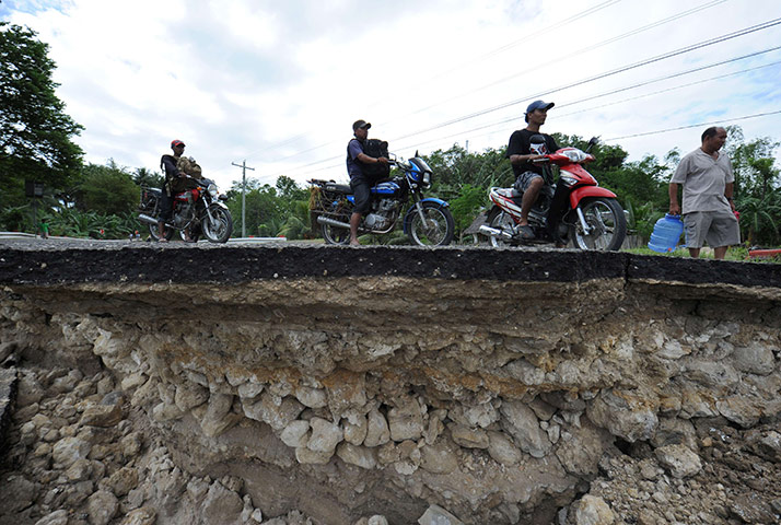 Philippines earthquake: Motorists wait for their turn to cross a damaged road