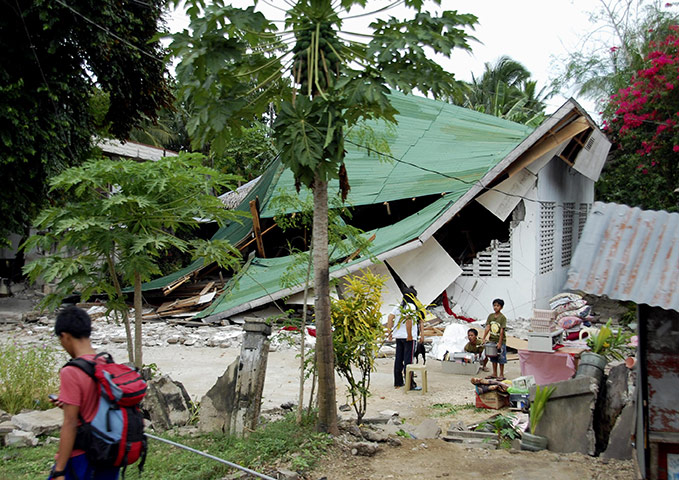 Philippines earthquake: Resident carry belongings after their house collapsed in an earthquake