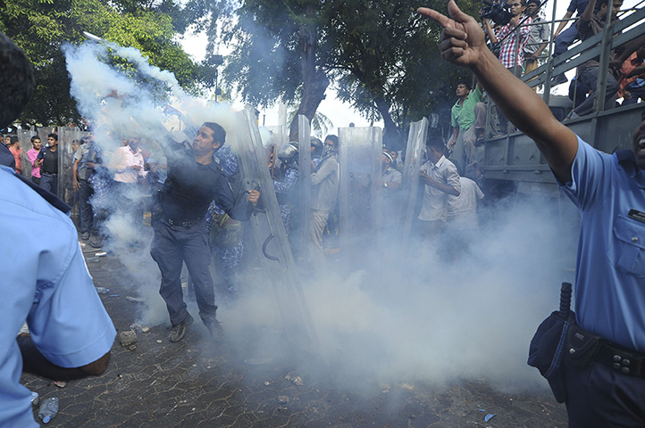 24 hours in pictures: Male, Maldives: Mutinying police are seen amid a cloud of tear gas
