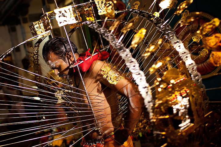 24 hours in pictures: Singapore: A devotee has his body pierced with hooks