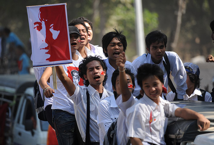 Aung San Suu Kyi campaign: Supporters wave pictures of Aung San Suu Kyi as they travel with her