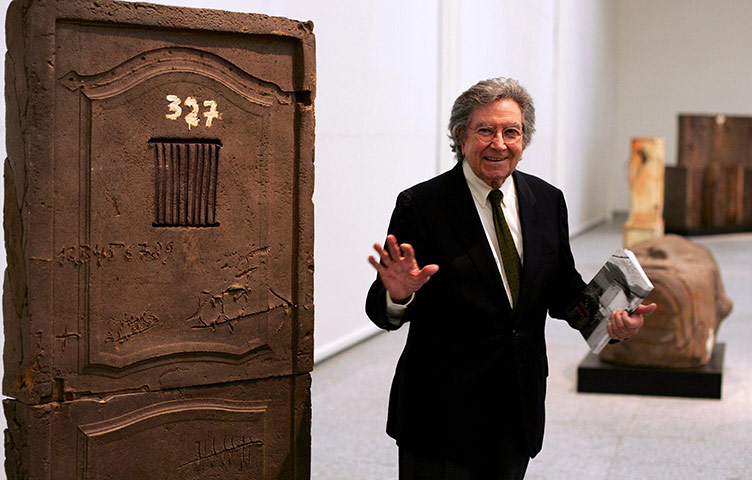 Antoni Tapies: Tapies poses next to one of his artworks