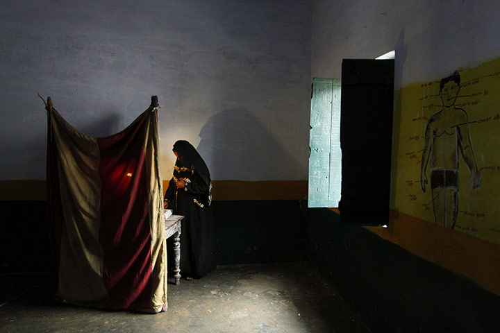 24 hours in pictures: An Indian Muslim woman casts her vote at a polling station