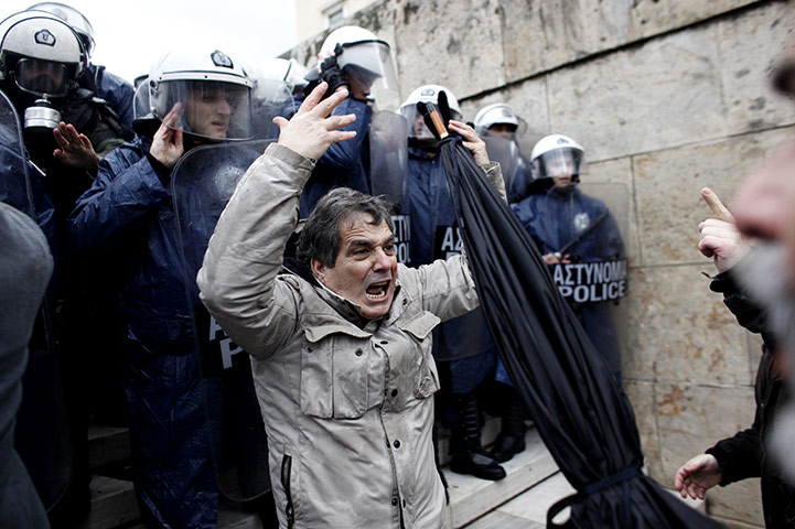 24 hours in pictures: Protesters clash with riot police as they try to enter parliament, Athens