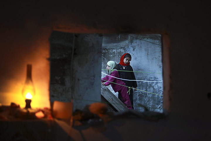 24 hours in pictures: Palestinian girls are seen through a window of their familiy's home
