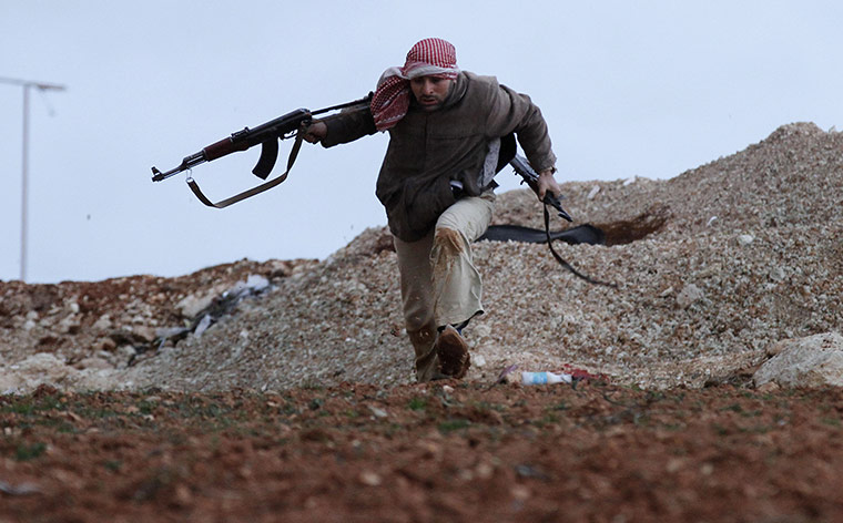 Syria clashes: A Syrian rebel runs for cover in Idlib