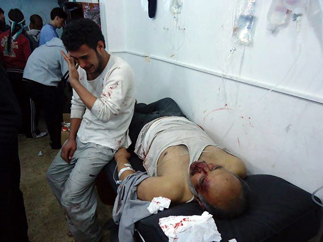 Syria clashes: Wounded men are seen in the Sunni Muslim district of Bab Amro in Homs