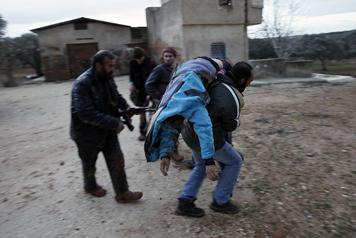 Syria clashes: A Syrian rebel evacuates an injured fellow rebel fight in Idlib