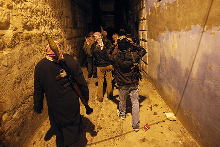 Syria clashes: Syrian rebels walk in an alley in Idlib