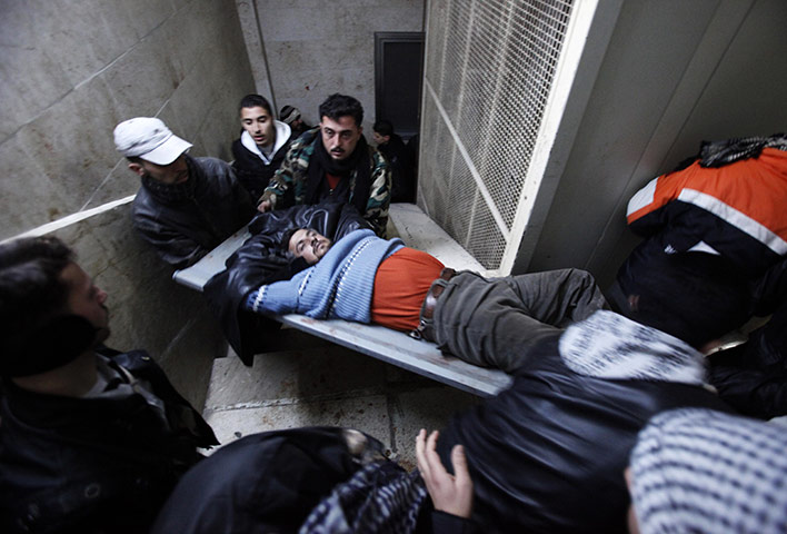 Syria clashes: An injured Syrian rebel fighter is carried into a local hospital Idlib