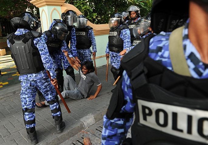 Maldives unrest: Maldivian police forcefully detain a protester in Male