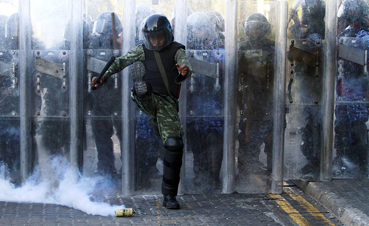 Maldives unrest: An army officer kicks a tear gas cannister during a clash 
