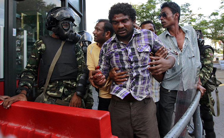 Maldives unrest: A supporter of the ousted president leaves a protest after being injured