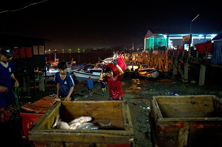 24 hours in pictures: Labourers transferring fish from boats to the wholesale market, Burma