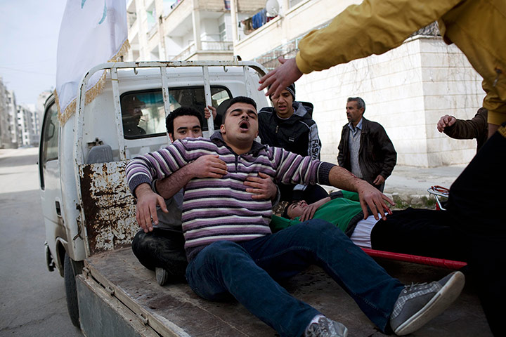 Syria Annan: Injured men are carried to a hospital in Idlib, Syria