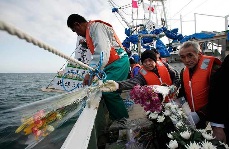 Japan anniversary: Fishermen throw flowers and lanterns into the sea as they offer prayers