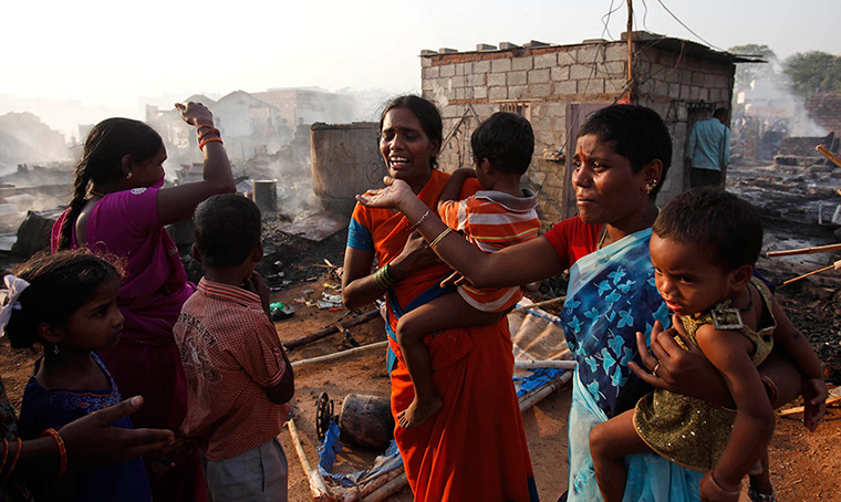 24 hours: Hyderabad, India: Indian women weep after their home was gutted in a fire