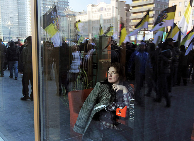 24 hours: Moscow, Russia: A woman in a cafe watches a rally for fair elections 
