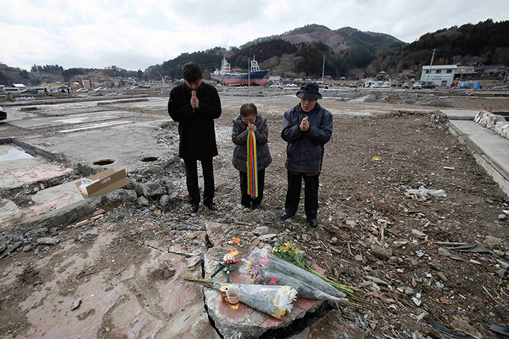 Japan tsumani: Masayuki Horii with friend and father pray for his wife 