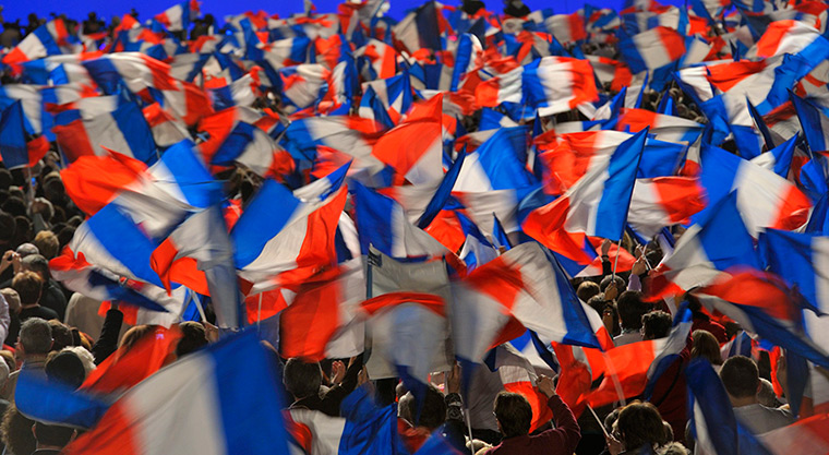 Sarkozy rally: Supporters wave flags as Nicolas Sarkozy delivers a speech at a rally 