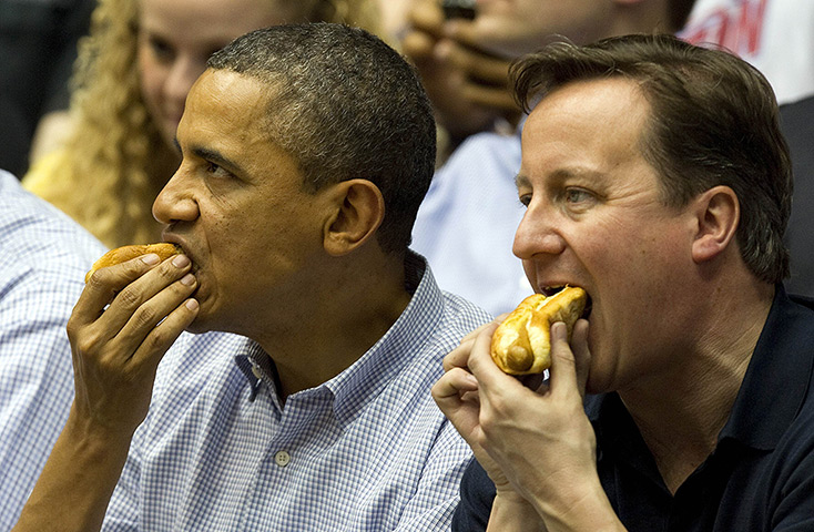 Camerons in US: Barack Obama and David Cameron eat hot dogs as they sit in the stands