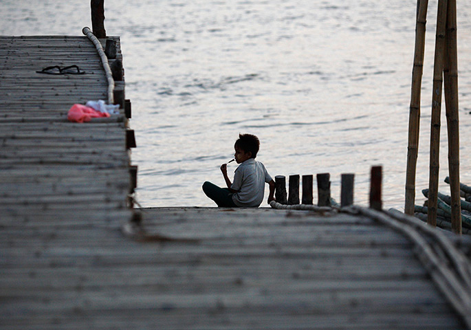 24 hours: Rangoon, Burma: A boy sits near the bank of the Yangon River 