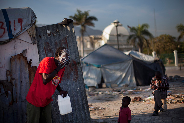 24 hours: Port-au-Prince, Haiti: A man washes his face outside a makeshift shelter