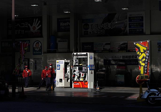 24 hours: Tokyo, Japan: Workers wait for customers at a petrol station