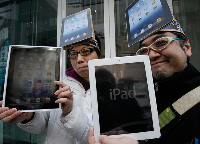 New iPad goes on sale: Tokyo, Japan: Ryota Musha and Hisanori Kogure show off new iPads