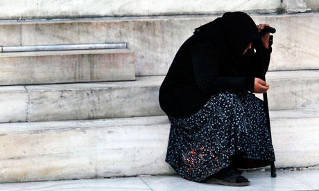 An old person is seen outside the Bank of Greece 