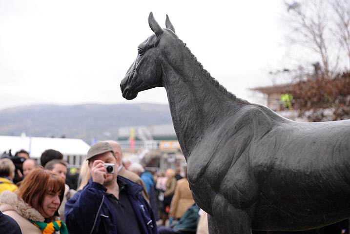 Cheltenham Gold Cup day: A spectator takes a photo of the statue of Arkle at Cheltenham