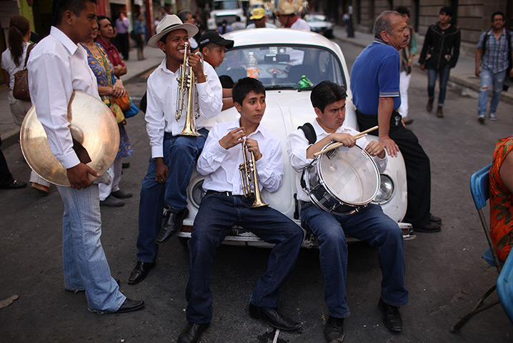 24 hours in pictures: Mexico City, Mexico: Members of a band sit on a car during a protest