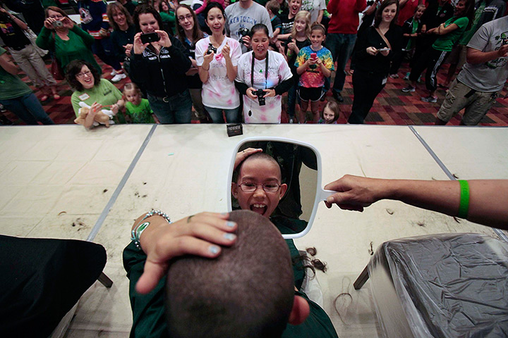 24 hours in pictures: Girl reacts reacts after the buzz cut during St. Baldrick event