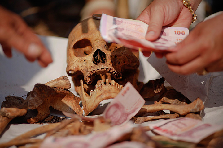24 hours in pictures: Banknotes are placed on unclaimed human remains taken out graves, Bangkok