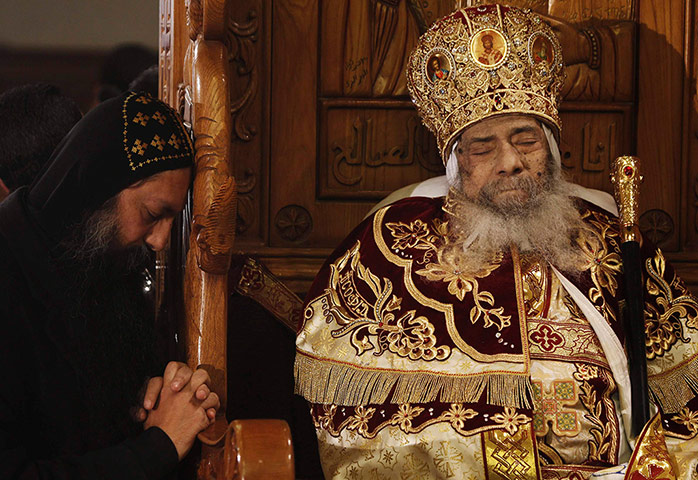 Pope Shenouda: A mourner prays next to the body of Pope Shenouda