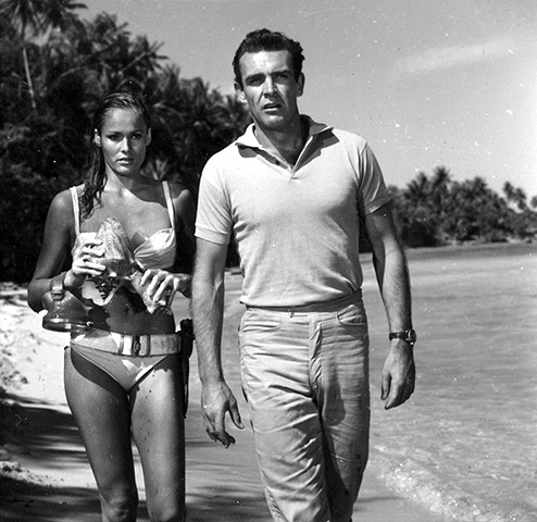 Fifty years of Bond style: James Bond and Honey Ryder walk along the beach