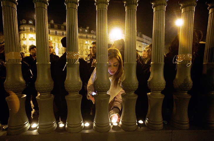 Toulouse shooting: A woman lights a candle on Place de la Bastille 