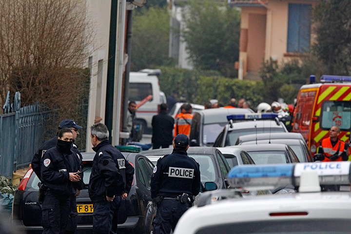 Toulouse raid: Police officers and firefighters stand next to a building in Toulouse