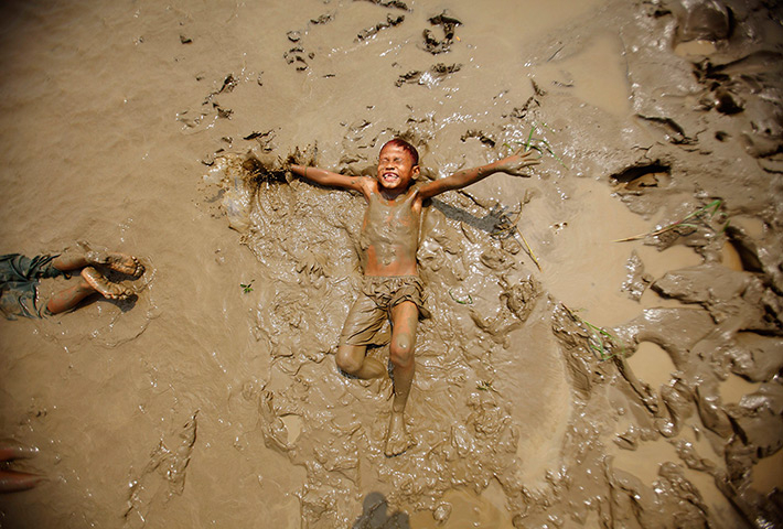 24 hours in pictures: A boy plays in the mud on the bank of the Bago river, Burma