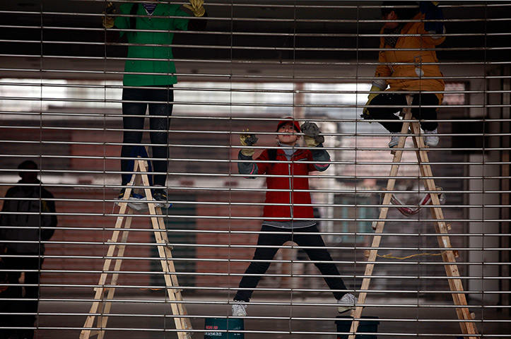 24 hours in pictures: Workers clean the grills of a gate in Beijing, China