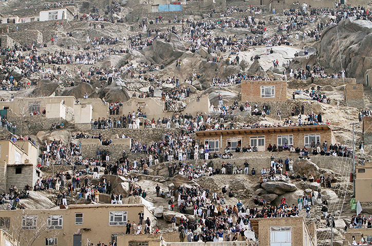 24 hours in pictures: Afghans gather on a hillside to watch the raising of the holy mace