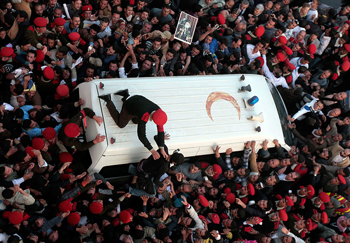 24 hours in pictures: Police restrain mourners surrounding ambulance carrying Pope Shenouda III