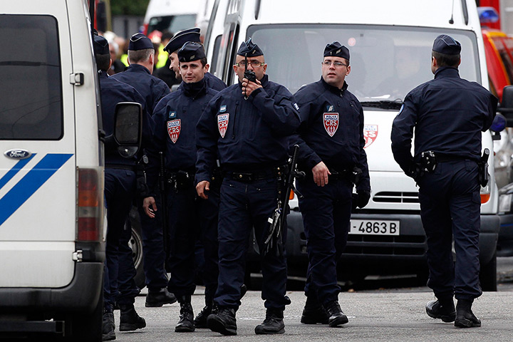 Toulouse siege: French CRS (riot control) police block a street during a raid on a house