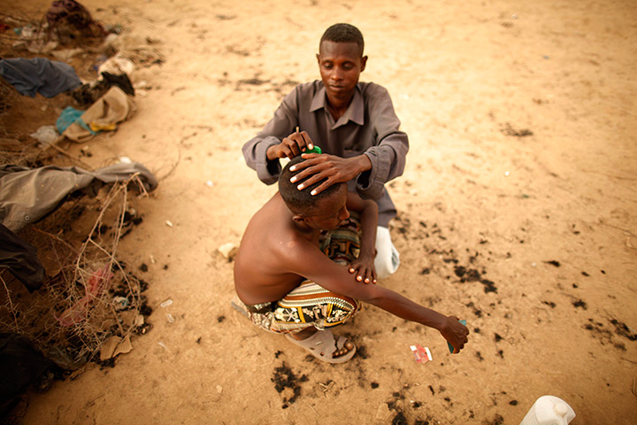 24 hours: Haradh, Yemen: An Ethiopian migrant gets a haircut 