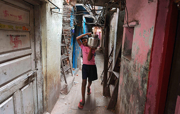 World Water Day: An Indian boy carries a stainless steel pot filled with drinking water